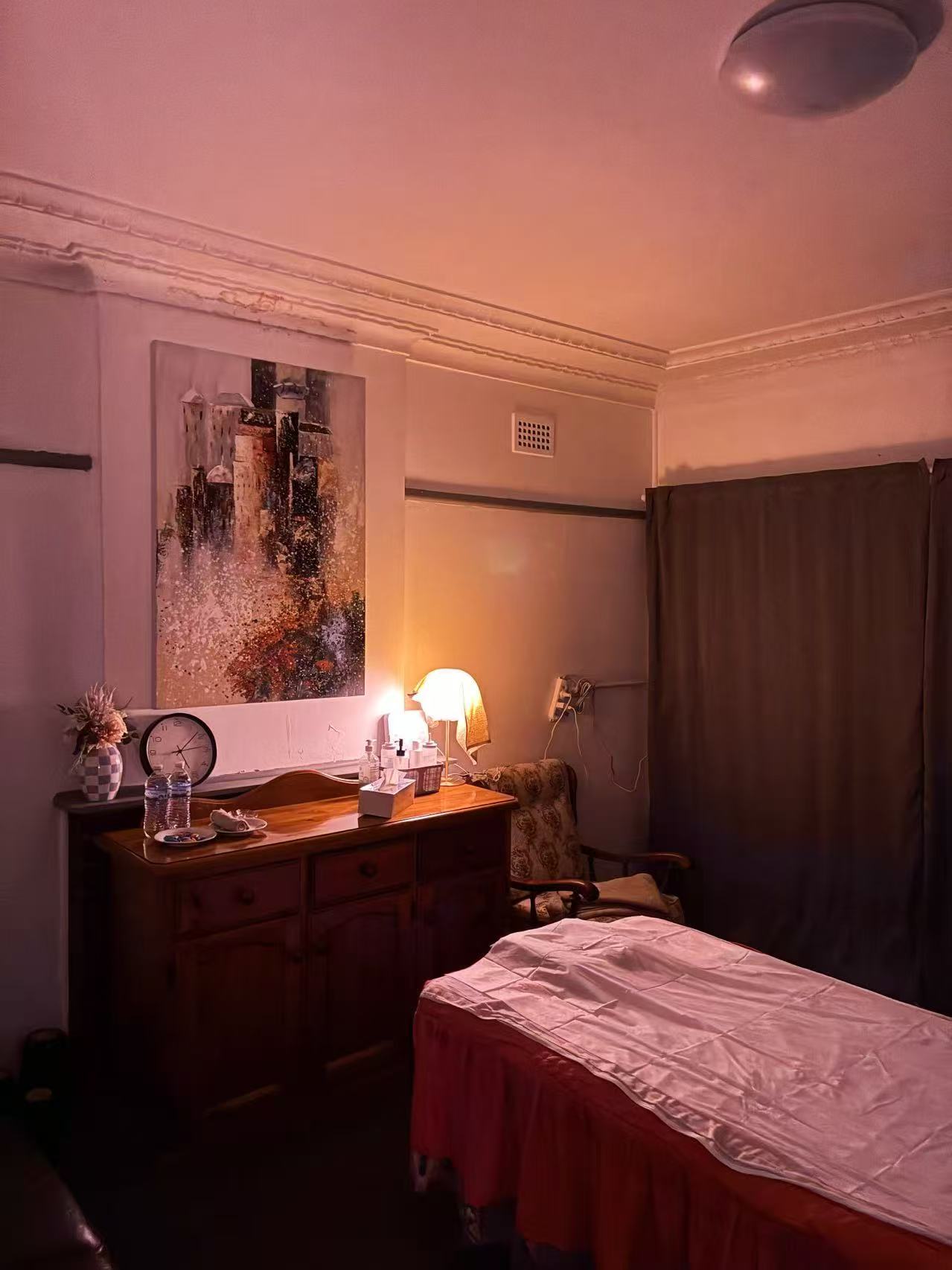 Private massage suite with warm ambient lamp and art